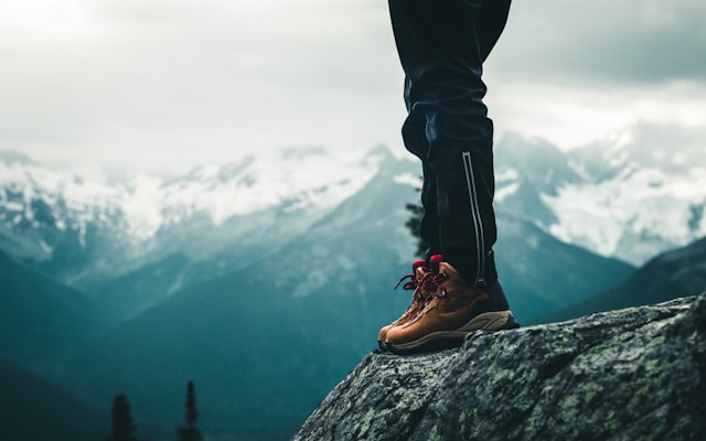 Man wearing hiking boots at the top of a mountain